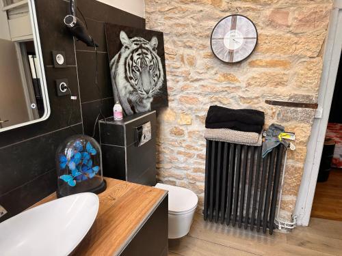 La salle de bains est pourvue d'une peinture de tigres sur le mur. dans l'établissement Charme&caractère, à Dijon