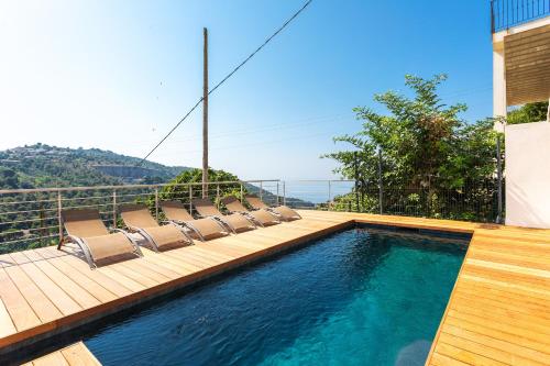 une piscine avec des chaises longues sur un balcon dans l'établissement LA TURBIE VISTA VI4422 By Riviera Holiday Home, à La Turbie