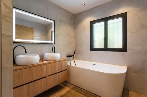 une salle de bain avec deux lavabos, une baignoire et un miroir dans l'établissement LA TURBIE VISTA VI4422 By Riviera Holiday Home, à La Turbie