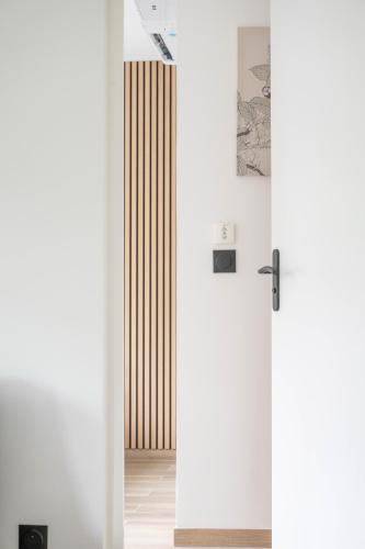 une porte pivotante dans une pièce aux murs blancs dans l'établissement Appartement Climatisé Porte Versailles, à Paris