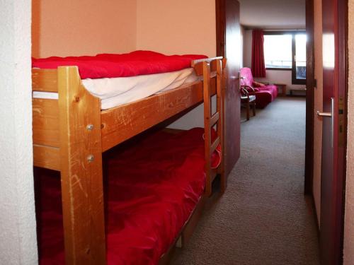 Cette chambre comprend 2 lits superposés avec des draps rouges. dans l'établissement Studio aux Orres 1650, Skis aux Pieds, 6 Pers, Balcon, Gardien, Animaux Adm - FR-1-322-596, aux Orres