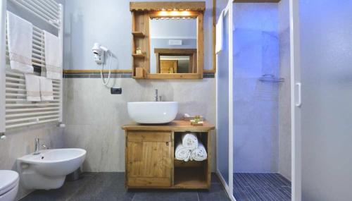 a bathroom with a sink and a toilet and a mirror at Mollino Rooms by Skilink (Winter) in Breuil-Cervinia