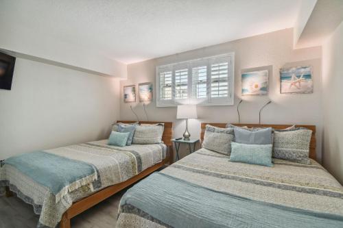 a bedroom with two beds and a window at Bayside Penthouse-5min to Beach, Rest & Shops in Clearwater Beach