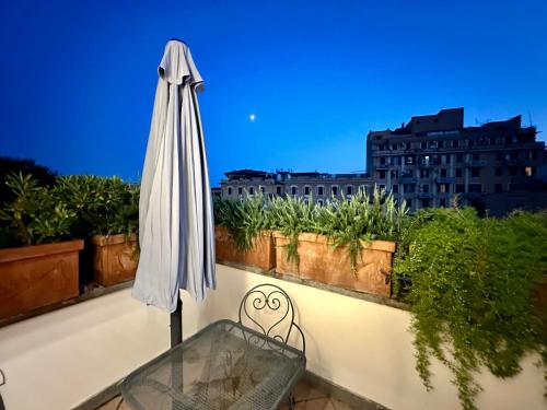 a white umbrella sitting on a balcony with a glass table at Hotel Principe Di Piemonte in Rome
