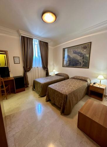 a hotel room with two beds and a television at Hotel Principe Di Piemonte in Rome