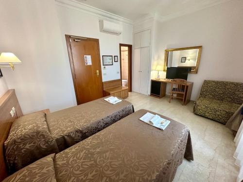 a hotel room with two beds and a couch at Hotel Principe Di Piemonte in Rome