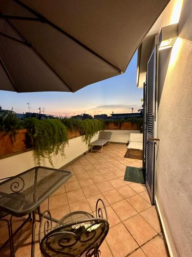 a patio with a table and chairs and an umbrella at Hotel Principe Di Piemonte in Rome