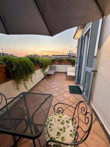 a balcony with a table and chairs and an umbrella at Hotel Principe Di Piemonte in Rome