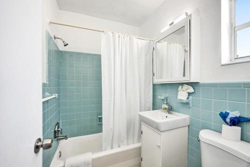 Un baño con lavabo, inodoro y ducha. en Waves On Desoto Beautiful Studio # 8, en Hollywood