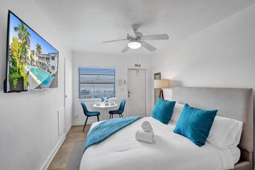 Un dormitorio con una cama con almohadas azules y una mesa. en Waves On Desoto Beautiful Studio # 8, en Hollywood
