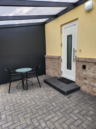 a patio with a table and chairs next to a door at Apartment im Hinterhof in Bersenbrück