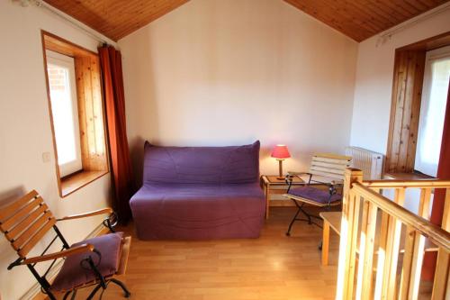 - un salon avec un canapé violet dans l'établissement Le puy neige, à Le Palais-sur-Vienne