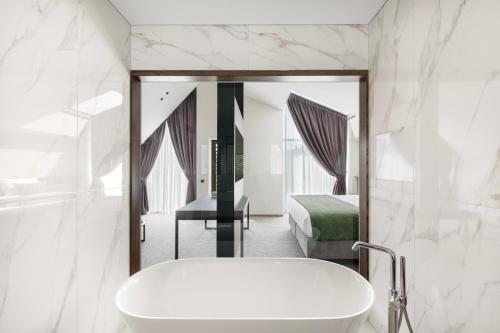 a bathroom with a sink and a bed and a mirror at Harmony Birštonas in Birštonas