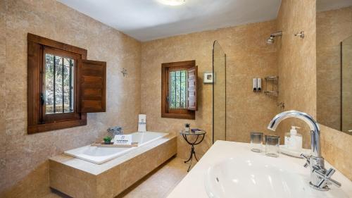 a bathroom with a tub and a sink and a shower at La Casa 1950 Montefrío by Ruralidays in Montefrío