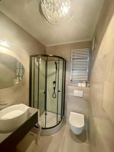 a bathroom with a shower and a sink and a toilet at Prime Browary Apartment in Warsaw