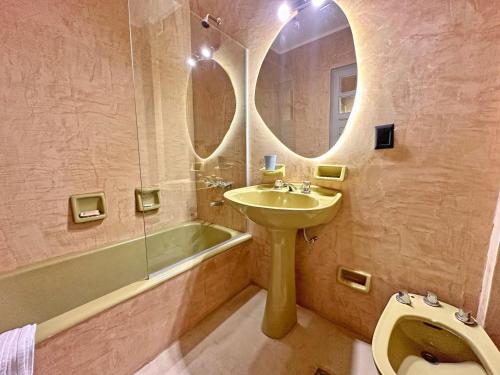 a bathroom with a sink and a mirror and a tub at Casa VanTitter in San Carlos de Bariloche
