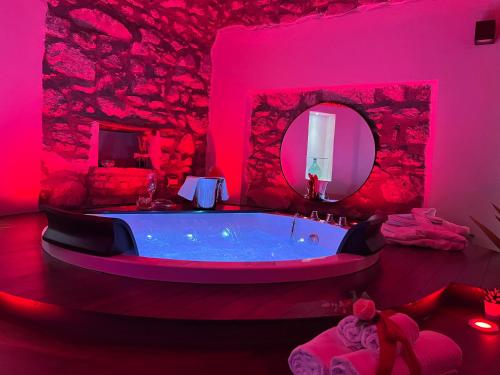 a bathroom with a large tub in a pink room at Vicolo72 in Calitri