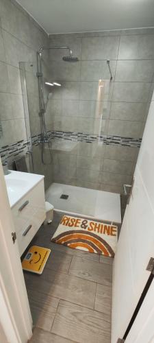 a bathroom with a shower and a sign on the floor at El Bungalow in Playa Fañabe