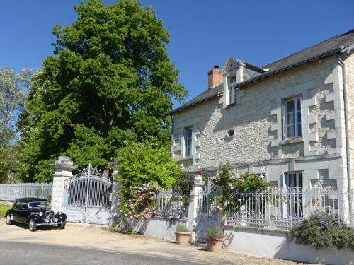 an old house with a car parked in front of it at Les jardins de Claunay in Claunay