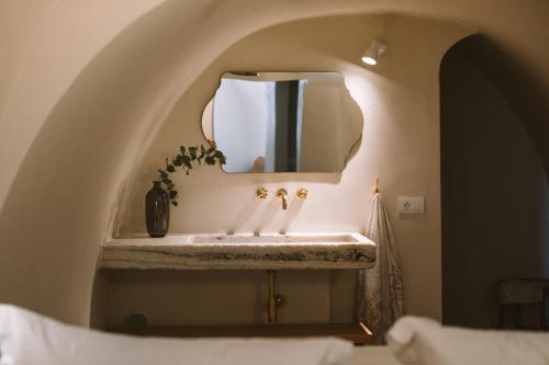 a bathroom with a sink and a mirror at Spitia Santorini Villa Collection in Oia