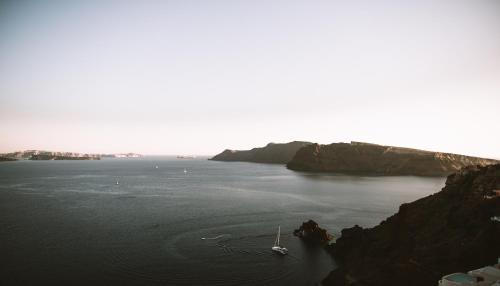 a boat in a large body of water at Spitia Santorini Villa Collection in Oia