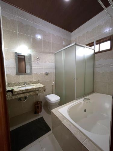 ein Badezimmer mit Badewanne, Toilette und Waschbecken in der Unterkunft Pousada Luna Zen in Pirenópolis
