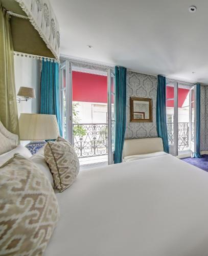 a bedroom with a large white bed and windows at Chalgrin Boutique Hotel in Paris