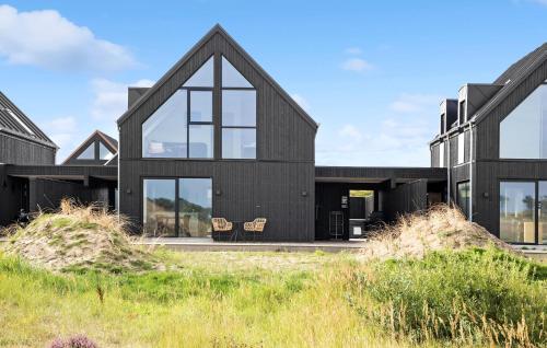 a black house with large windows at Lovely Home In Skagen With Kitchen in Skagen