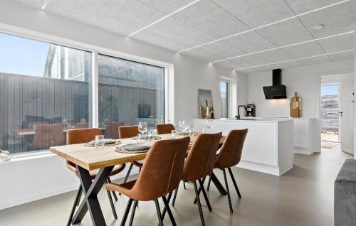 a dining room and kitchen with a table and chairs at Lovely Home In Skagen With Kitchen in Skagen