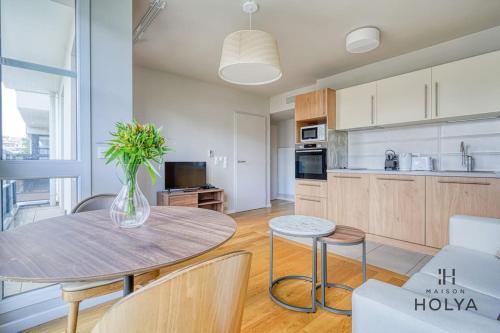 une cuisine et une salle à manger avec une table et des chaises dans l'établissement Le Subtil - Aux portes de Paris - 365B, à Issy-les-Moulineaux