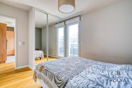 une chambre avec un lit et une grande fenêtre dans l'établissement Le Subtil - Aux portes de Paris - 365B, à Issy-les-Moulineaux