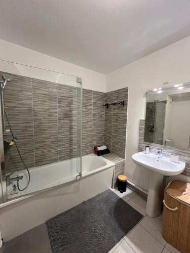 une salle de bain avec une baignoire, un lavabo et une douche dans l'établissement Appartement cosy proche Paris, à Villepinte