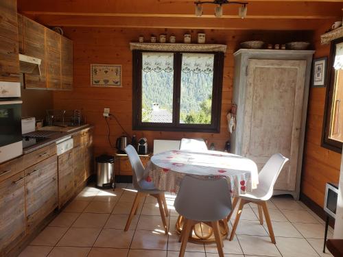 une cuisine avec une table et des chaises et une fenêtre dans l'établissement Chalet La Nanda Devi, aux Houches