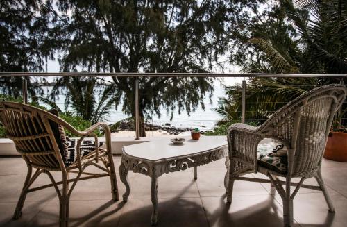 two chairs and a coffee table on a patio at Villa Les Sablons in Petit Raffray