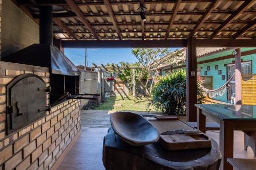 a patio with an outdoor oven and a table at Pousada Hanalie by Easy Hotéis in Praia do Rosa