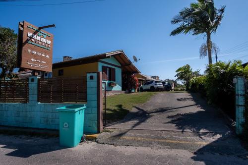 a building with a trash can next to a street at Pousada Hanalie by Easy Hotéis in Praia do Rosa