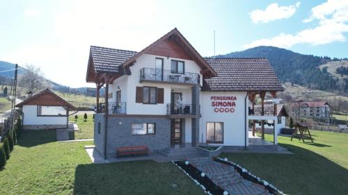 a small house on top of a green field at Pensiunea Simona in Rodna