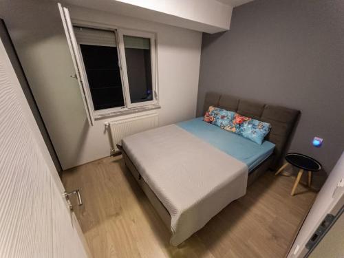 a small bedroom with a bed and a window at Guest House Avtokomanda in Železara