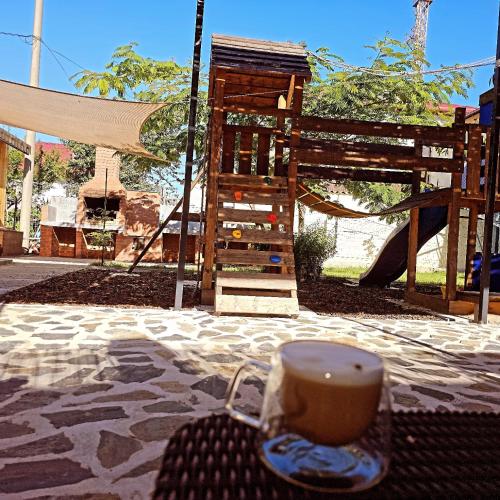 a cup of coffee sitting on a table next to a playground at Casuta Noastra - Sulina in Sulina