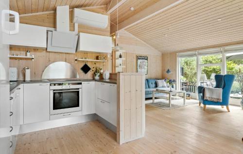 a kitchen and living room with white cabinets and blue chairs at 2 Bedroom Cozy Home In Højslev in Højslev