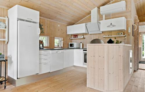 a kitchen with white appliances and a wooden ceiling at 2 Bedroom Cozy Home In Højslev in Højslev
