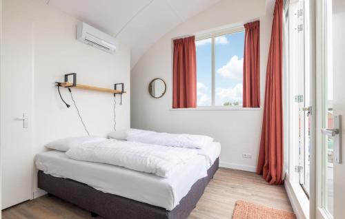 two beds in a room with a window at Saskerlei in Uitgeest