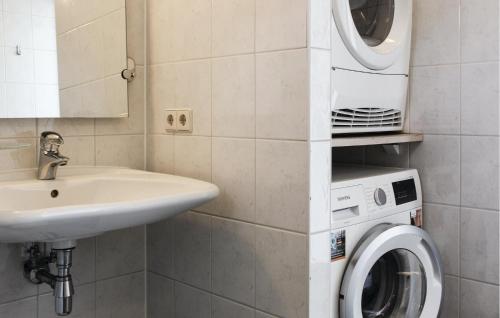 a bathroom with a washing machine and a sink at Kraaijennest in Uitgeest