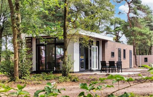 a house with glass doors and chairs in the woods at 2 Bedroom Amazing Home In Hellendoorn in Hellendoorn
