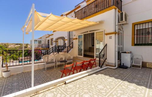 a patio with chairs and an umbrella on a house at Stunning Home In San Fulgencio in San Fulgencio
