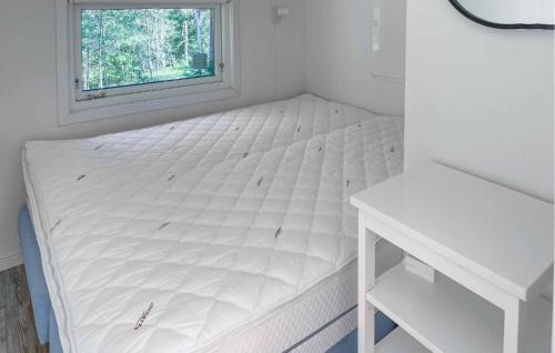 a white bed in a room with a window at Gorgeous Home In Ljusterö in Norra Ljustero