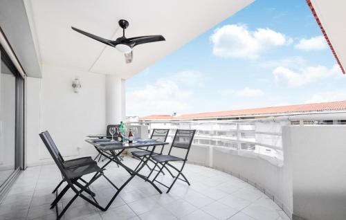 Elle dispose d'un balcon avec une table et des chaises ainsi que d'un ventilateur de plafond. dans l'établissement 1 Bedroom Stunning Apartment In Antibes, à Antibes