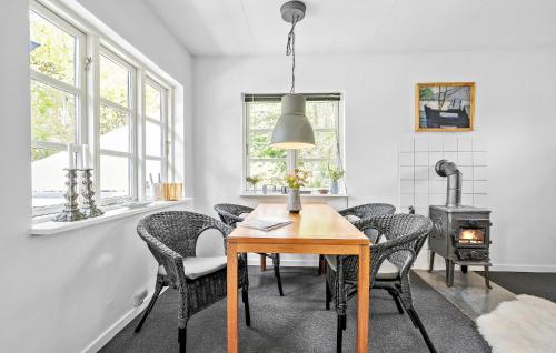 a dining room with a table and chairs and a wood stove at Cozy Home In Sjællands Odde With Wifi in Yderby