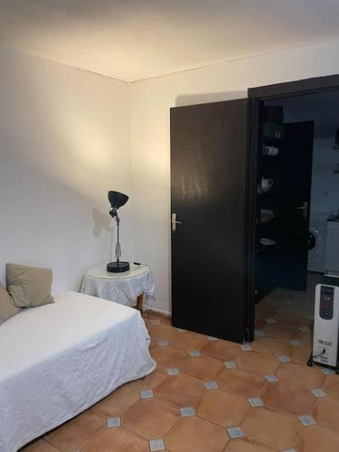 une chambre avec un lit et une table avec une lampe dans l'établissement Spacious ground floor apartment in town centre, à Hendaye