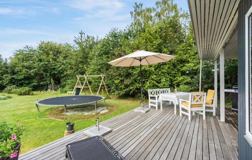 VejbyにあるLovely Home In Vejby With Kitchenの木製デッキ(テーブル、傘付)